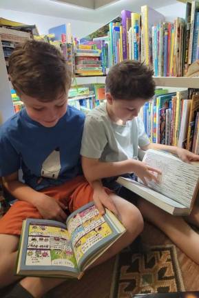 <b>Rowan and Isaac Martens reading at home in Minisink, N.Y. The Martens were the first in their town to sign up for a Port Jervis, N.Y., library card, but because it’s a 19-minute drive, they rarely get there. Now, with newly limited access, it becomes still less convenient, but they plan to make the effort to go this summer. ‘I want my kids to have the library experience,’ Melissa Martens said, ‘even if it’s not convenient.’ (Photo by Melissa Martens)</b>