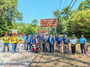 Assemblymember Christopher Eachus, Cornwall Supervisor Josh Wojehowski, veterans and others stand in front of the recently unveiled Catholic War Veterans Memorial Highway sign on Route 32.