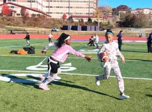 Girls practice pulling flags at the flag football clinic.