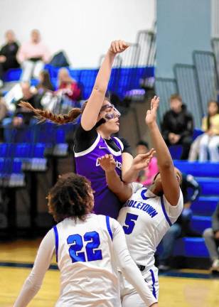 Crusader Sienna Feeley, with a face mask, shoots over a Middie defender.