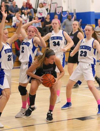 Photos by William DimmitSurrounded: Caroline Helbeck (#11) comes down with a big rebound in the second half of the game.