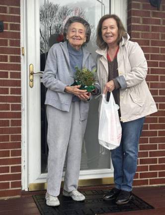 Dori Driscoll, right, a volunteer with Meals on Wheels of Greater Newburgh, presents a Christmas tabletop arrangement to client Anna Alessi, along with her noontime hot meal. The arrangements, distributed to clients on Dec. 11, were prepared and donated by the Garden Club of Orange &amp; Dutchess Counties. For more information about Meals on Wheels of Greater Newburgh, call 845-562-3490 weekday mornings, or visit <a rel=nofollow href=http://www.mealsonwheelsnewburgh.org>mealsonwheelsnewburgh.org</a>.