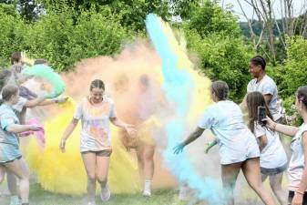 Runners get covered with colors as they near the end of the color run.