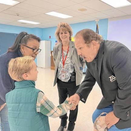 A student shakes the hand of a veteran.