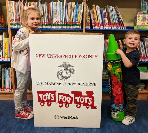 Provided photo Monroe Free Library-goers Samantha and Zach Marsico pose with the Toys for Tots donation bin.