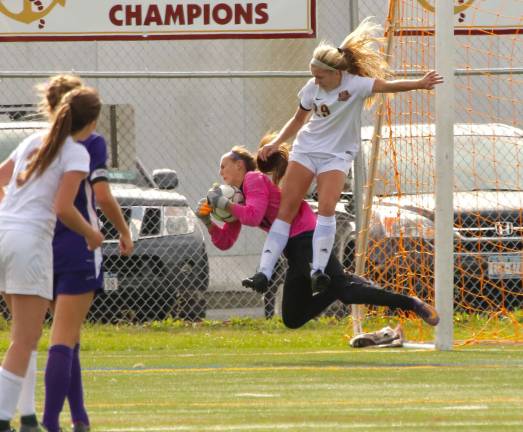 Crusader goalie Angela Fini makes a spectacular save with an Arlington player all over her in the second half.