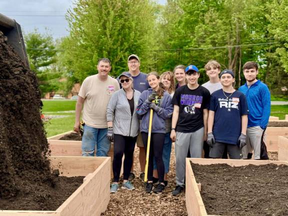 Kelly Imhof, center, with shovel, and her crew of volunteers build the Monroe Community Garden.