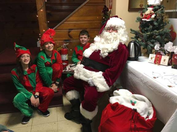 Photos provided Santa and his elves relax in this 2016 photo at Our Father's Kitchen at Sacred Heart Chapel in Monroe, in between dinner seatings for Christmas dinner prepared by Monroe Temple volunteers. He'll be back on Christmas day to see dinner guests and bring presents.