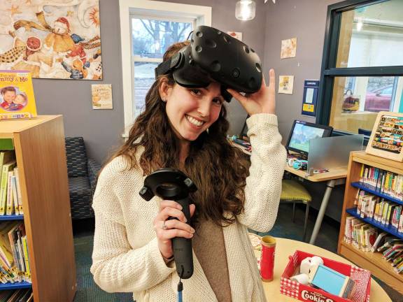 Photo provided Children's library assistant Kaylee Valentin shows the VR headset and controller.