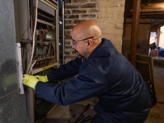 John Berdecia disassembles the furnace at a residential home Nov. 22 in Middletown.