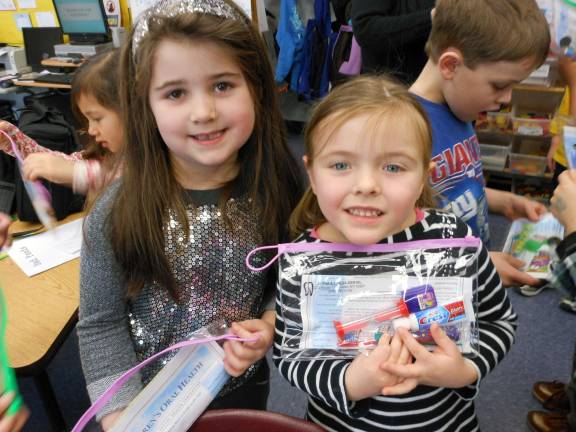 George Grant Mason kindergarten students Emilia Stillo and Ava Rattazzi show off their dental &igrave;goodie bags&icirc; from Dr. Se-A Chung, from Alpha &amp; Omega Dental, who recently came to the school to emphasize to young students the importance of establishing good dental habits.