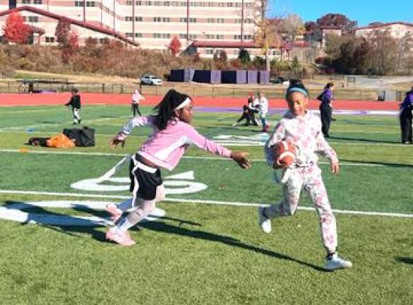 Girls practice pulling flags at the flag football clinic.