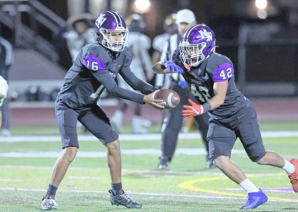 Quarterback Ethan Maldonado, #16, hands the ball off to Noah Flores, #42.