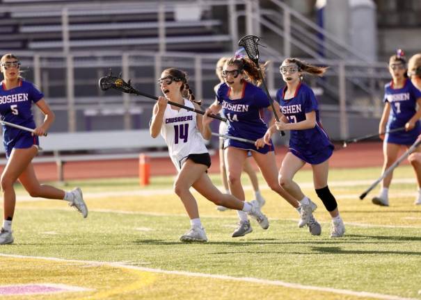 Crusader Madison Gollinger (#14) races up field with Gladiators in pursuit at Monroe-Woodbury High School last week.