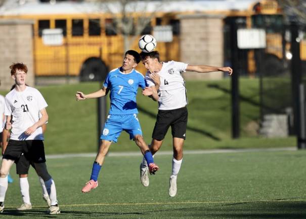 Justin Niaj, #4, heads the ball off a goalie kick.