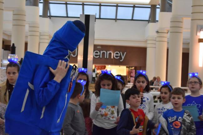 Dreidel Man spins while kids from the Chabad Hebrew School sing Chanukah songs.