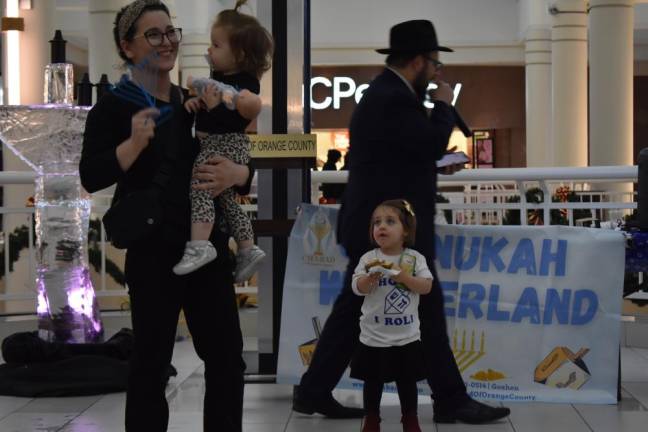 The winner of a menorah collects her prize. Behind her is the ice menorah.