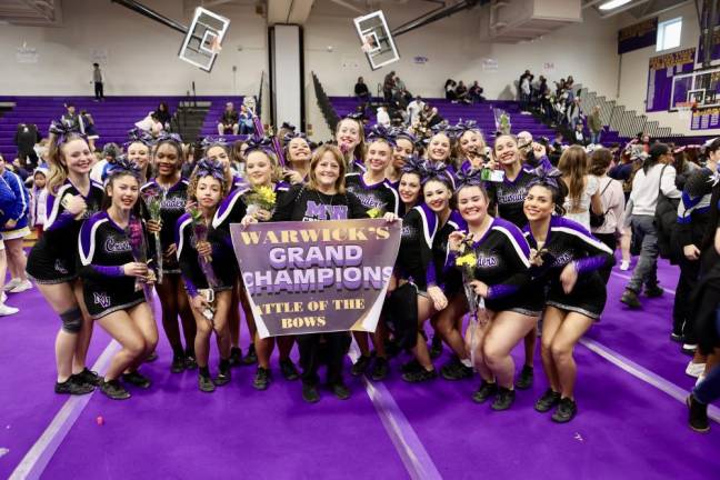 Head Coach Barbra Alidad holds the banner as her varsity team is named grand champions at The Battle of the Bows.