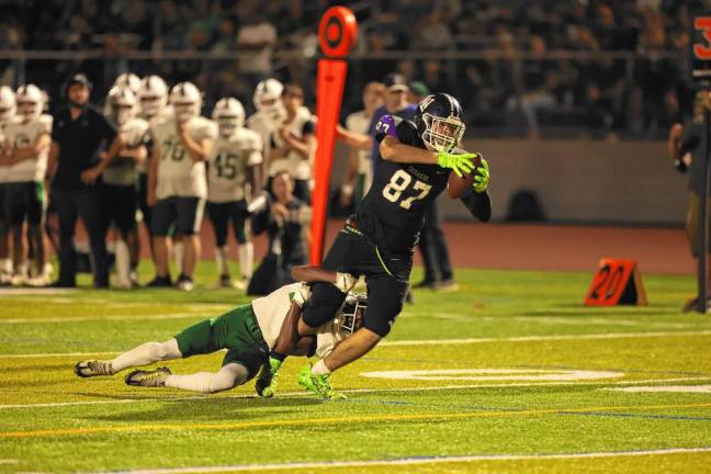 Charlie Theokas, #87, drags his defender as he makes a key first down late in the game.