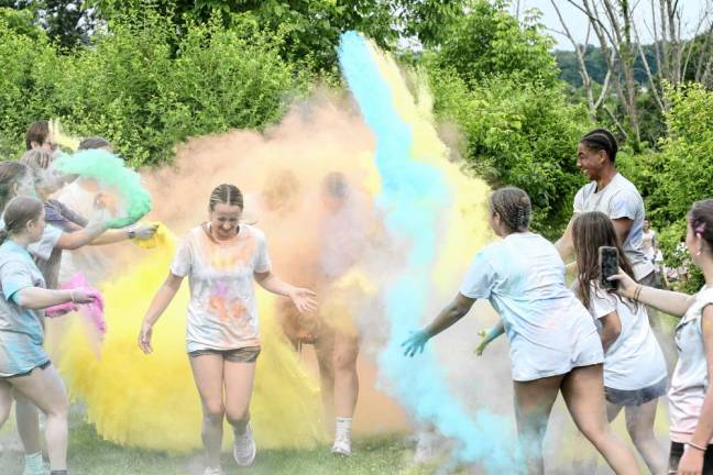 Runners get covered with colors as they near the end of the color run.