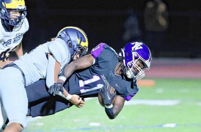 Roland Graham, #11, dives extra yardage with a Bushmen defender holding on.