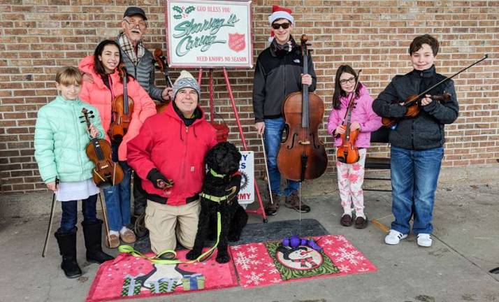 The Allegro Youth Orchestra are pictured here at Monroe&#x2019;s Stop &amp; Shop where they gathered to support Salvation Army&#x2019;s Cliff Berchtold who was watching over the kettle and ringing accompanied by his Standard Poodle Rocket.