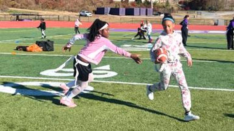 Girls practice pulling flags at the flag football clinic.